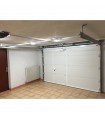 Porte de garage sectionnelle motorisée refoulement au plafond avec portillon intégré.