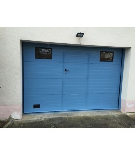Porte de garage sectionnelle plafond avec portillon ton bleu clair et hublots