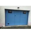 Porte de garage sectionnelle plafond avec portillon ton bleu clair et hublots